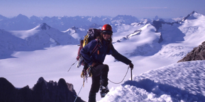 Outdoor education student completing a glacier ascent with sweeping views of snow-covered peaks.