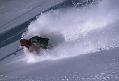 Skier enjoying fresh powder on backcountry mountain slope in Alaska