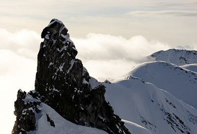 Skier descending steep ridge in Takshanuk Mountains