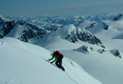 Backcountry mountaineering student ascending a snow-covered peak in Alaska.