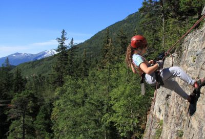 Student rappelling down a rock face during an outdoor climbing course in Alaska.