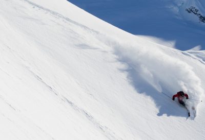 Backcountry skier practicing expert steep-skiing techniques on a heli-supported expedition.