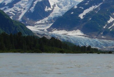 Guided raft team approaching a massive Alaskan glacier on a wilderness leadership course.