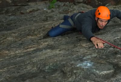 Rock climbing student practicing slab climbing technique during a guide training course.