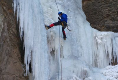 Technical ice climbing on a frozen waterfall in Utah’s mountains.