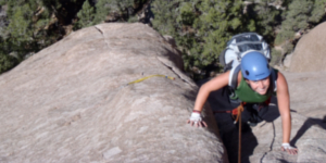 Climber ascending a sandstone crack route in Utah during a backcountry leadership and technical skills course.
