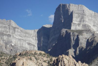 Massive vertical rock walls in a remote Utah canyon landscape.
