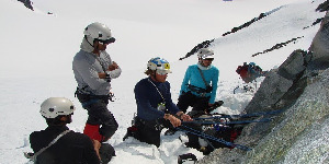 Mountaineering students practicing snow anchors during a glacier training session in Alaska.