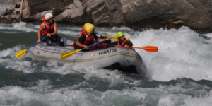 Whitewater rafters maneuvering through turbulent water.